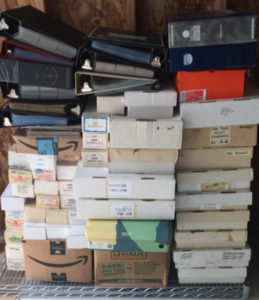 A pile of assorted boxes and binders showing a trading card collection for sale.
