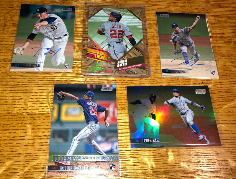 A selection of "hits" from a box of 2021 Topps Stadium Club baseball cards, featuring two autographed cards, a photographers proof card, and an orange refractor card.